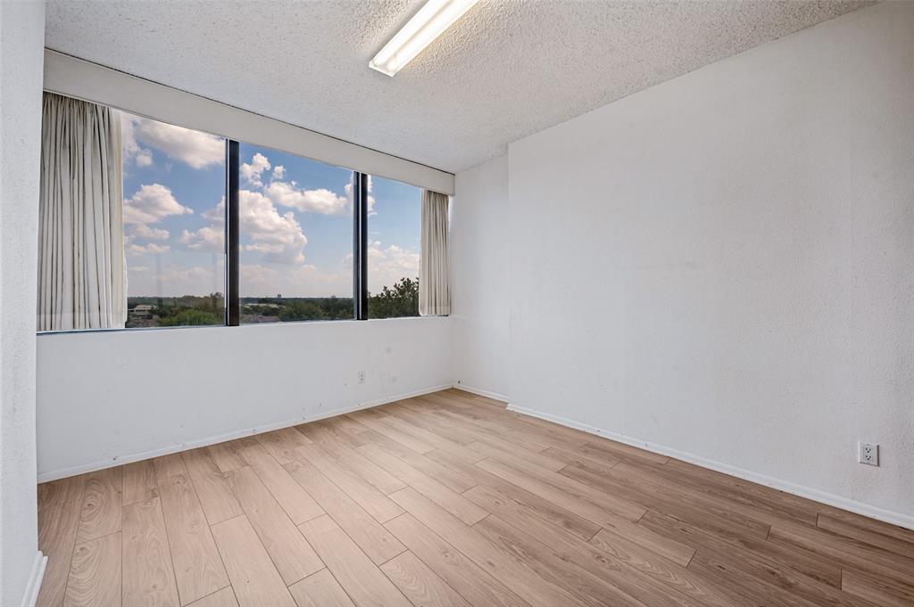 Expansive floor-to-ceiling windows featuring natural lighting and wood-finish flooring