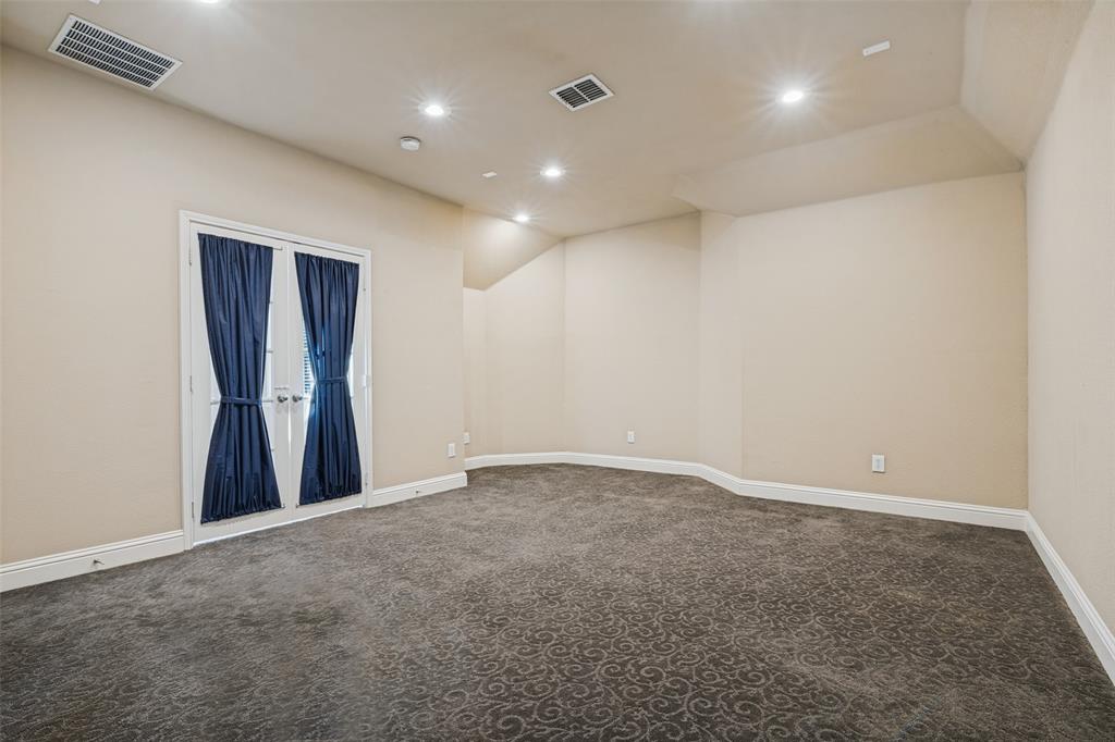 Room featuring patterned carpeting, recessed ceiling lighting, and double glass-panel doors