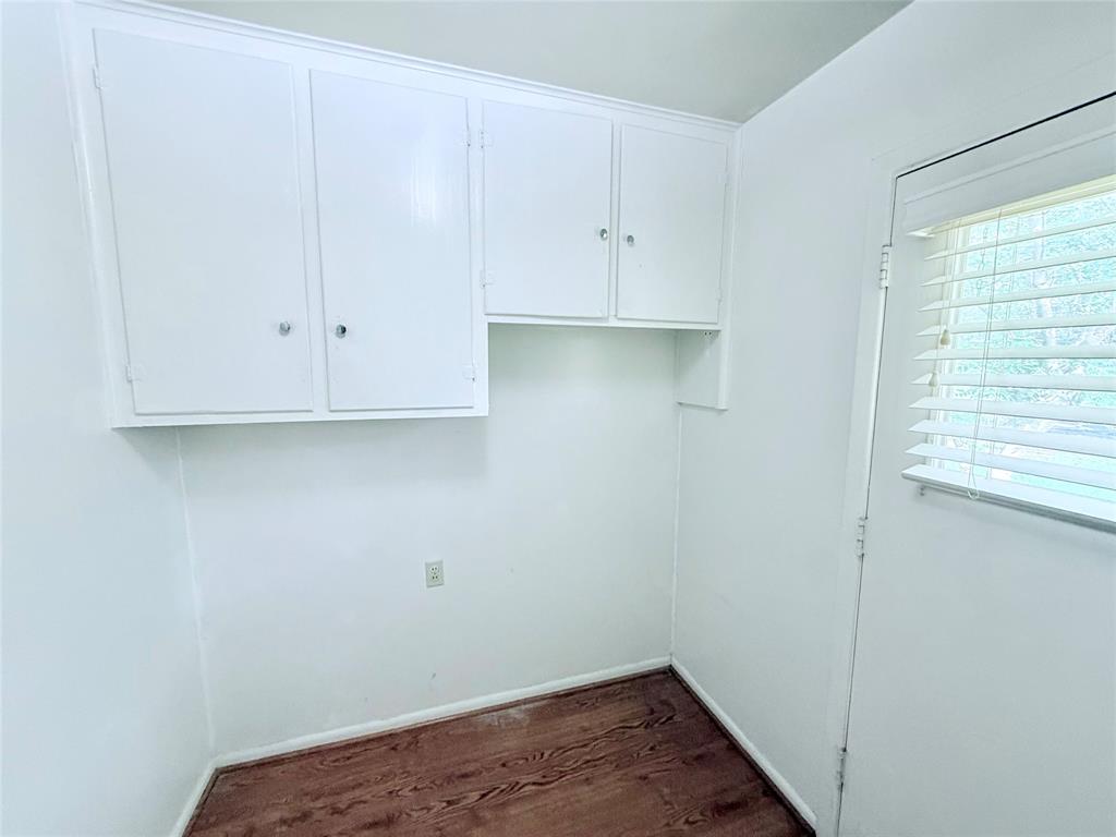 White built-in upper cabinetry, wood-finish flooring, and horizontal window blinds
