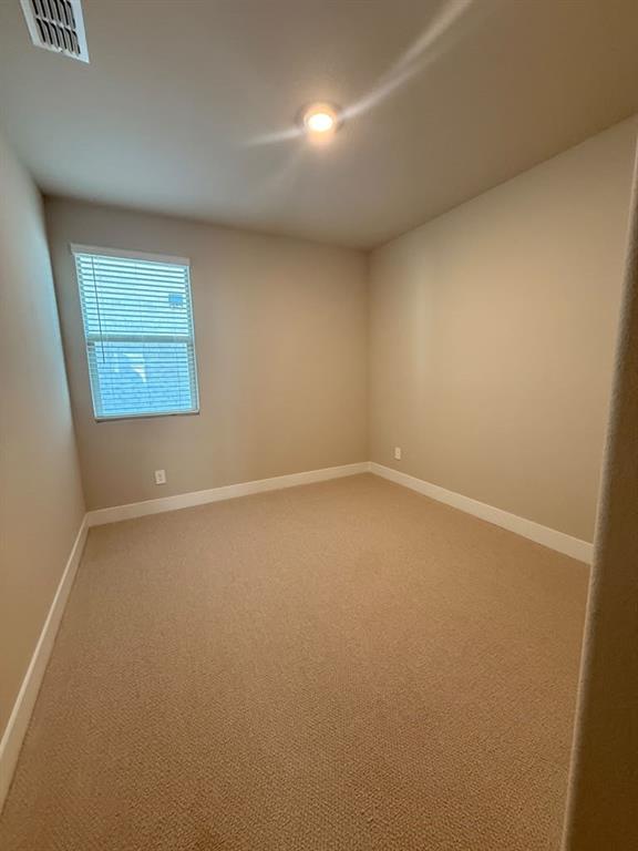 Neutral-toned interior space featuring neutral wall paint, wall-to-wall carpeting, and a window with horizontal blinds