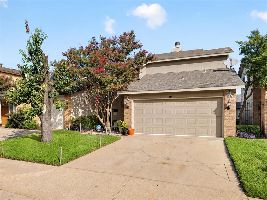 Two-story exterior featuring a mix of brick and siding, concrete driveway, attached two-car garage, and established landscaping