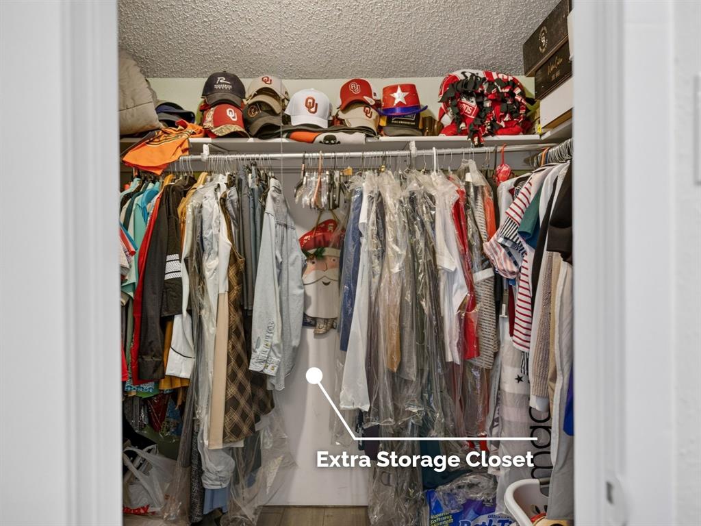 Walk-in closet featuring upper shelving and a full-width hanging rod