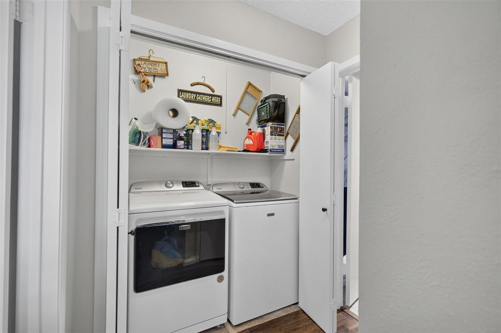 Laundry closet featuring a built-in overhead shelf and dual bi-fold doors
