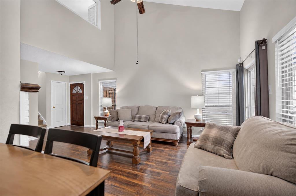 Vaulted ceilings, wood-finish flooring, recessed lighting, and large windows with horizontal blinds