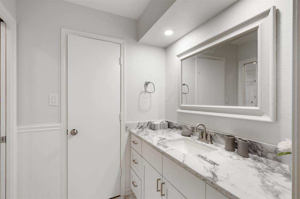 Primary bathroom features granite counters and storage built in.
