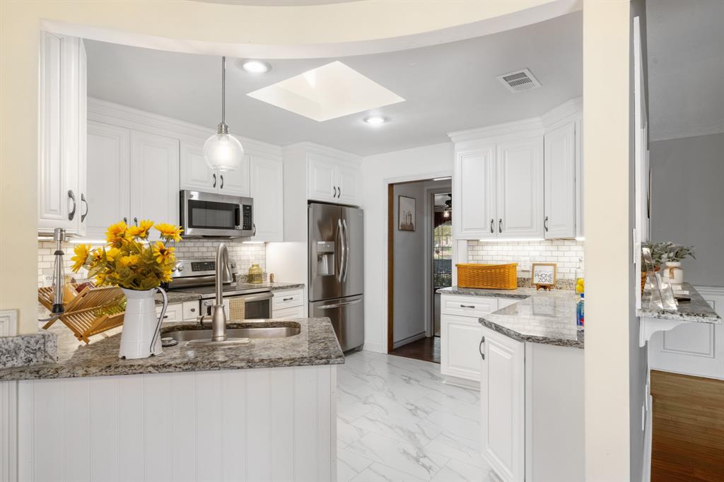 The kitchens backsplash compliments the countertops and cabinets beautifully.