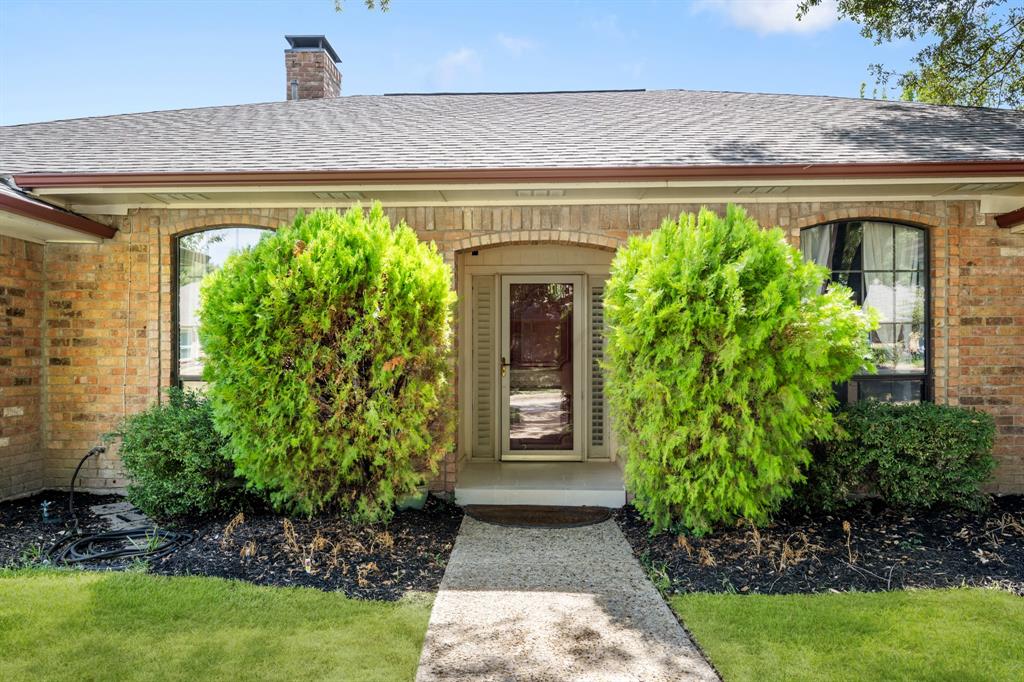 Charming front entry highlighted by classic brick detailing, mature manicured shrubs, and thoughtfully landscaped flower beds. A welcoming walkway leads to the inviting entry, creating a polished and well-maintained first impression.