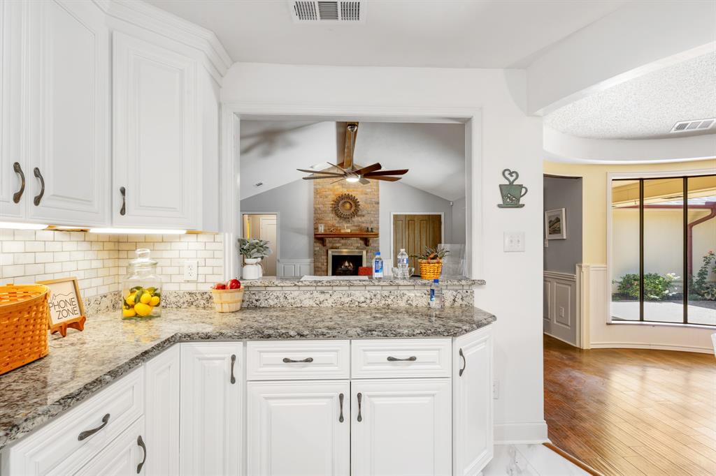 Kitchen has a breakfast bar and a view of the living room.