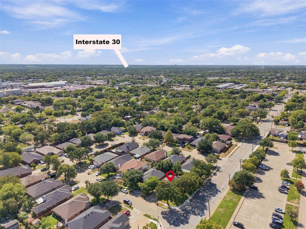Aerial perspective showing a residential property with a shingle roof and mature canopy trees