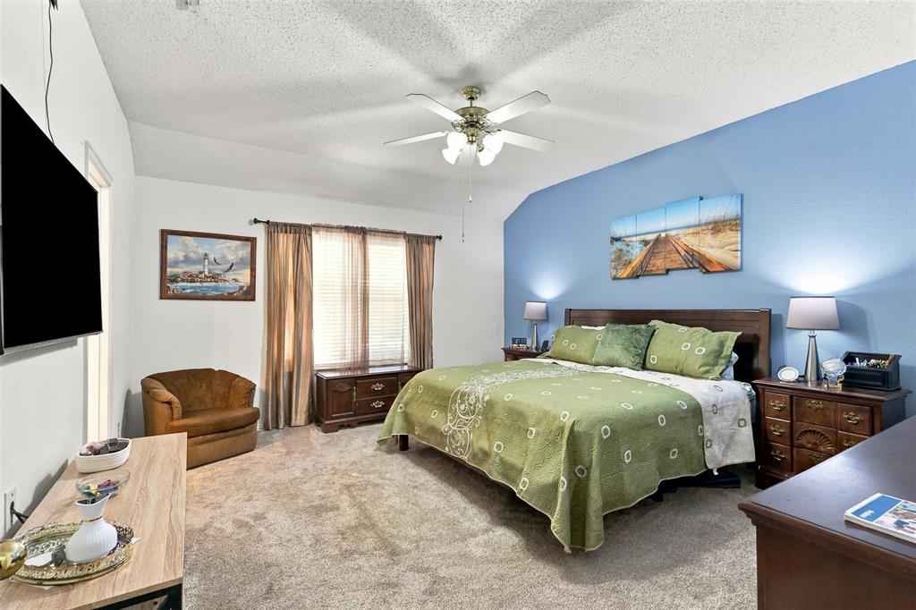 Vaulted ceiling with a central multi-blade ceiling fan and wall-to-wall carpeting