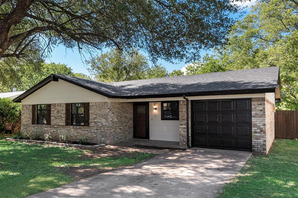 Single-story brick exterior featuring a multi-textured facade, a covered entryway, an attached single-car garage with a paneled door, and dark-toned shutter accents