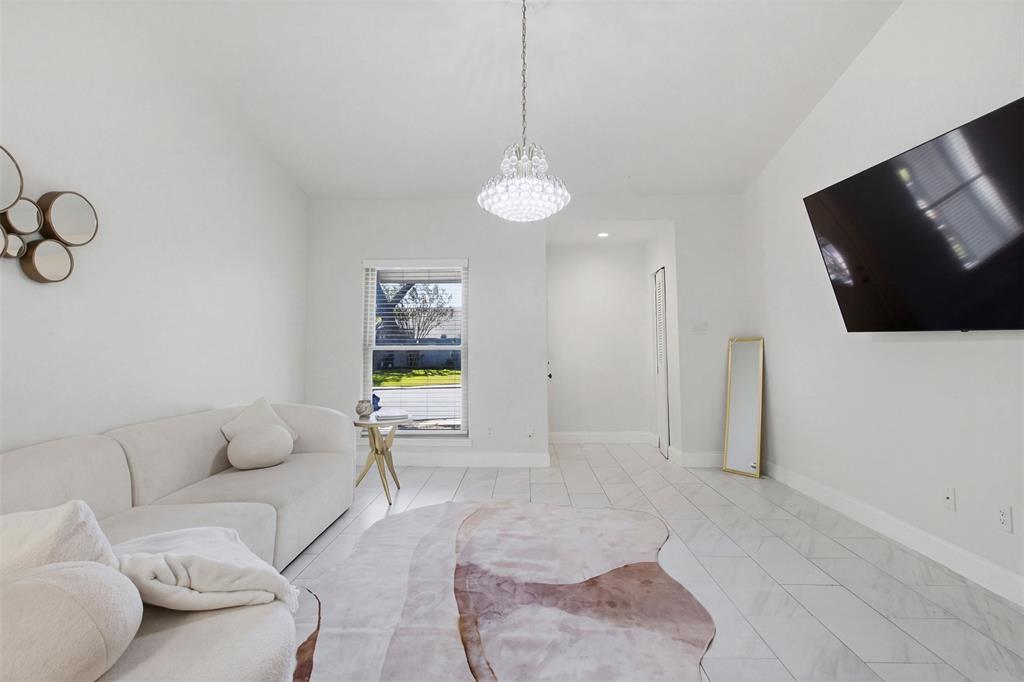 High ceilings, tile flooring, and a decorative crystal-style pendant light fixture