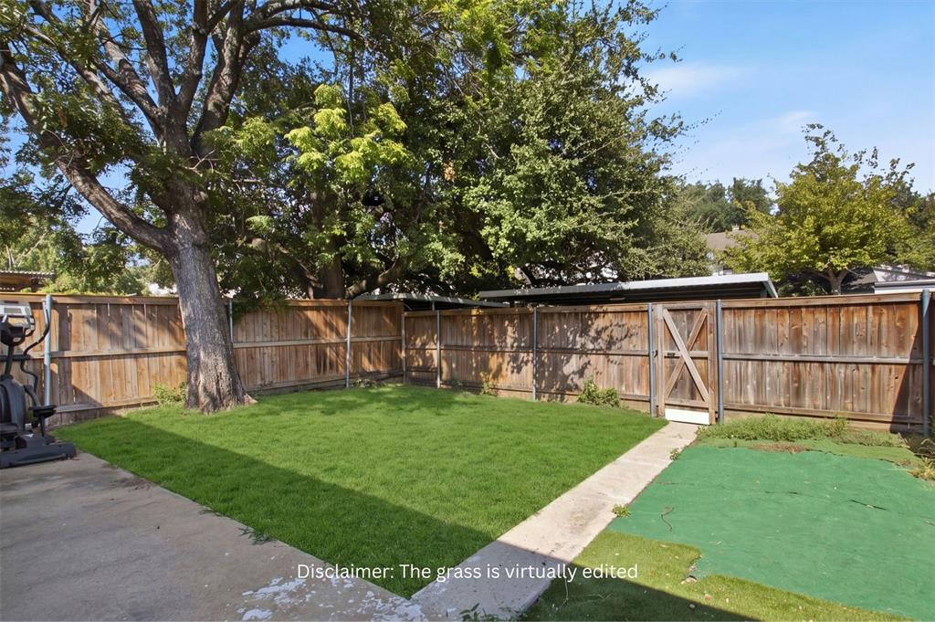 Backyard featuring a concrete patio, wood privacy fencing, mature trees, and a wooden gate