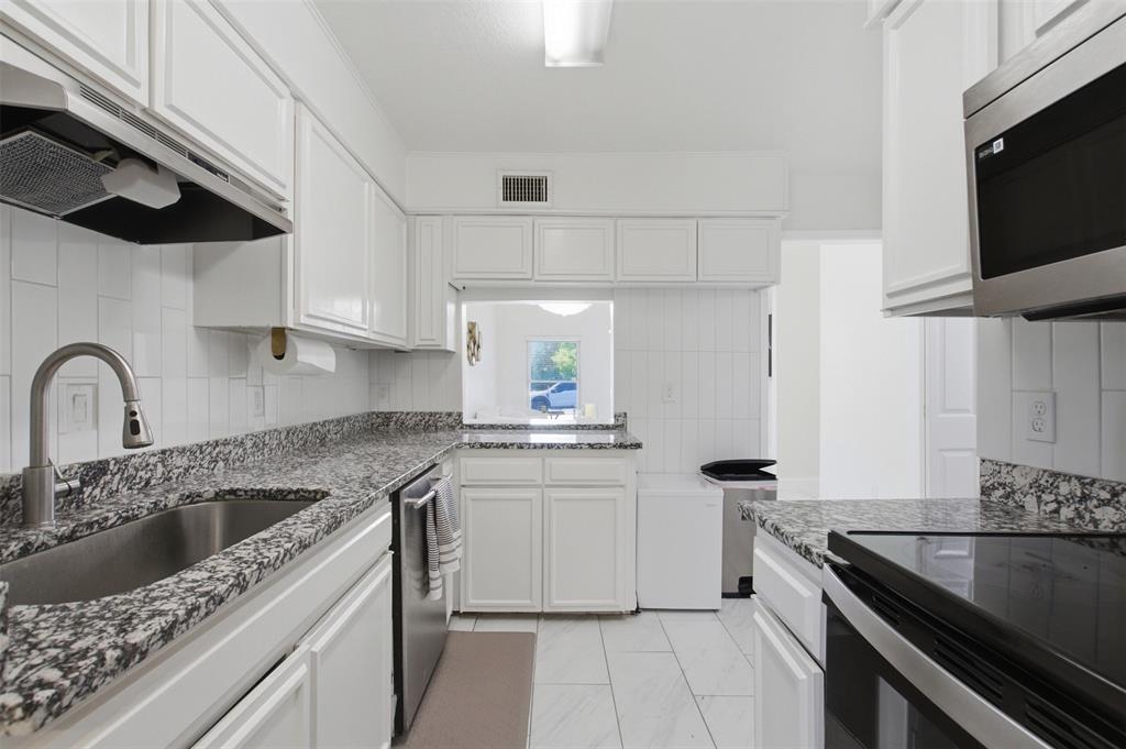 Kitchen featuring white cabinetry, stone-finish countertops, stainless steel appliances, a pull-down kitchen faucet, and tile flooring
