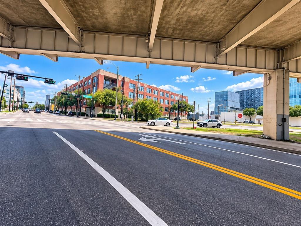 Multi-story brick commercial building featuring multi-pane windows and a concrete overpass structure