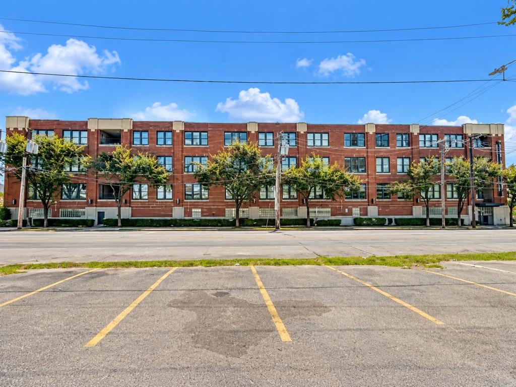 Four-story brick exterior featuring a multi-pane window grid, stone-capped roofline, and ground-level glass block accents Four-story brick exterior featuring a multi-pane window grid, stone-capped roofline, and ground-level glass block accents