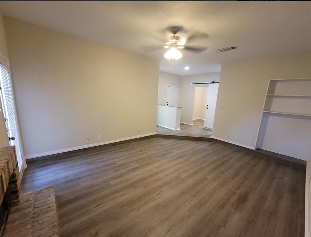 Living room with fireplace, built-in shelf & fan