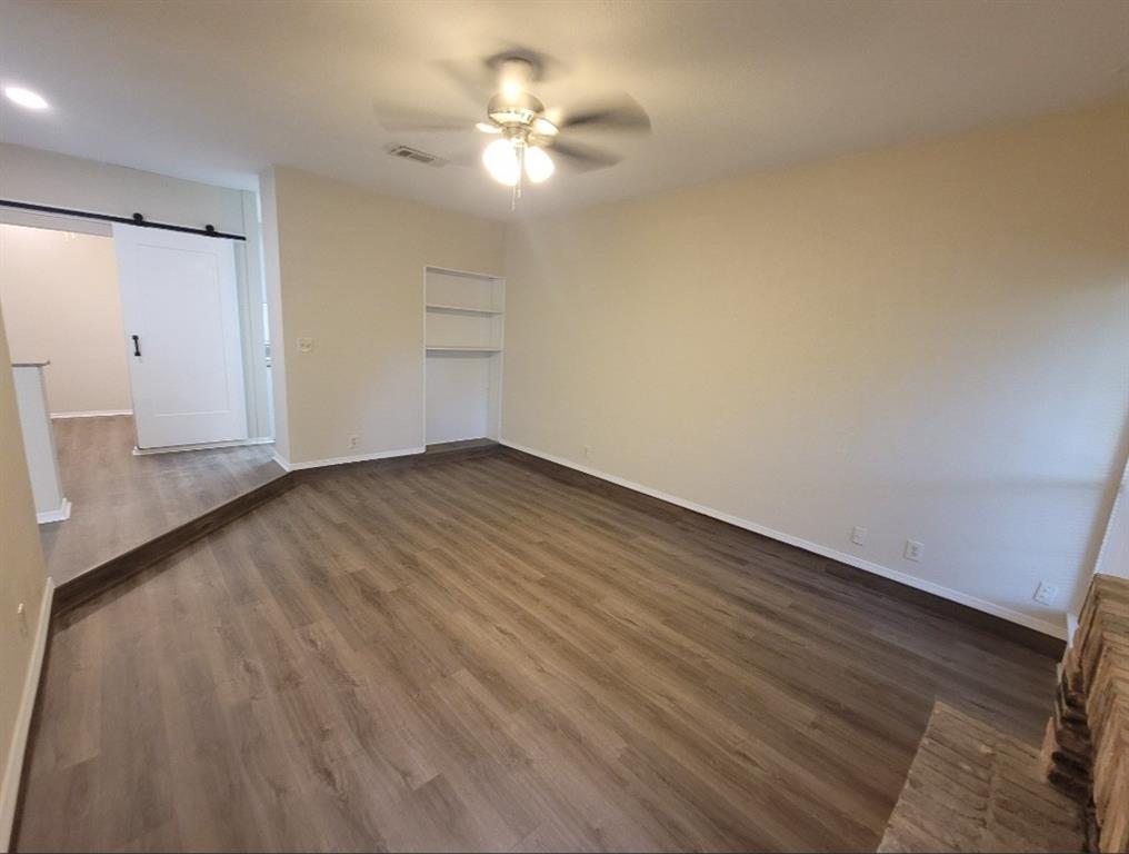Living room with fan and built in shelving