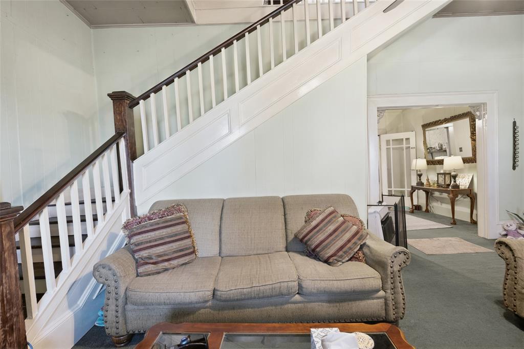 Open staircase featuring white balusters, stained-wood newel posts, and decorative paneling