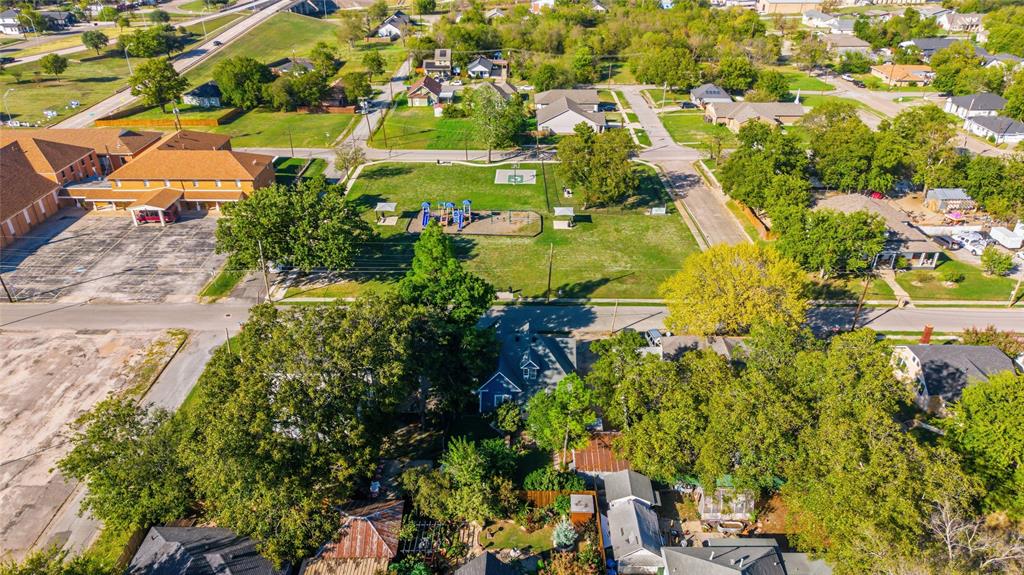 Aerial perspective of a residential lot featuring mature trees, established landscaping, and a fenced yard perimeter Aerial perspective of a residential lot featuring mature trees, established landscaping, and a fenced yard perimeter