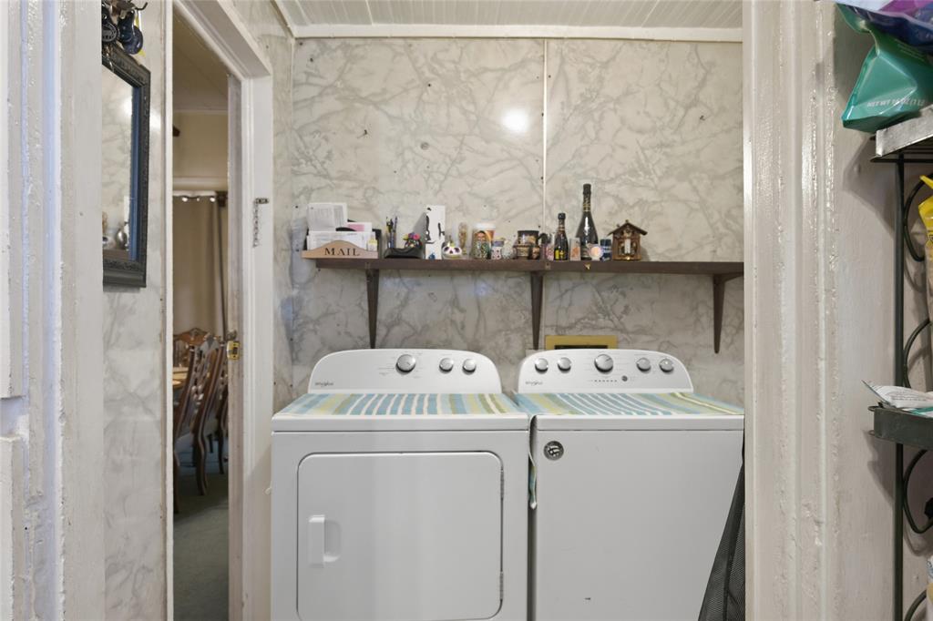 Laundry area featuring wall-mounted shelving and stone-patterned wall surfacing