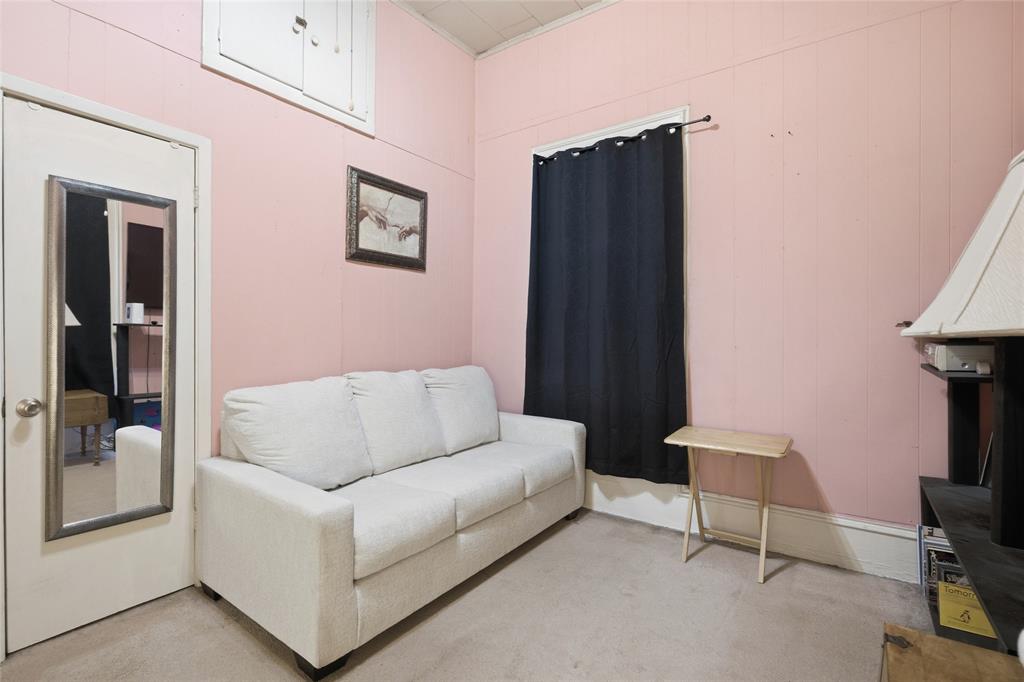 Interior space featuring paneling, carpeted flooring, and a ceiling-level access hatch