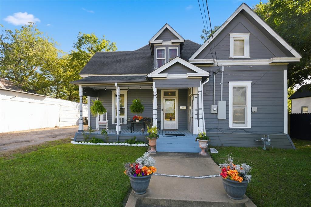 Gabled roofline exterior featuring lap siding, an expansive covered front porch, decorative porch columns, and a concrete walkway Gabled roofline exterior featuring lap siding, an expansive covered front porch, decorative porch columns, and a concrete walkway
