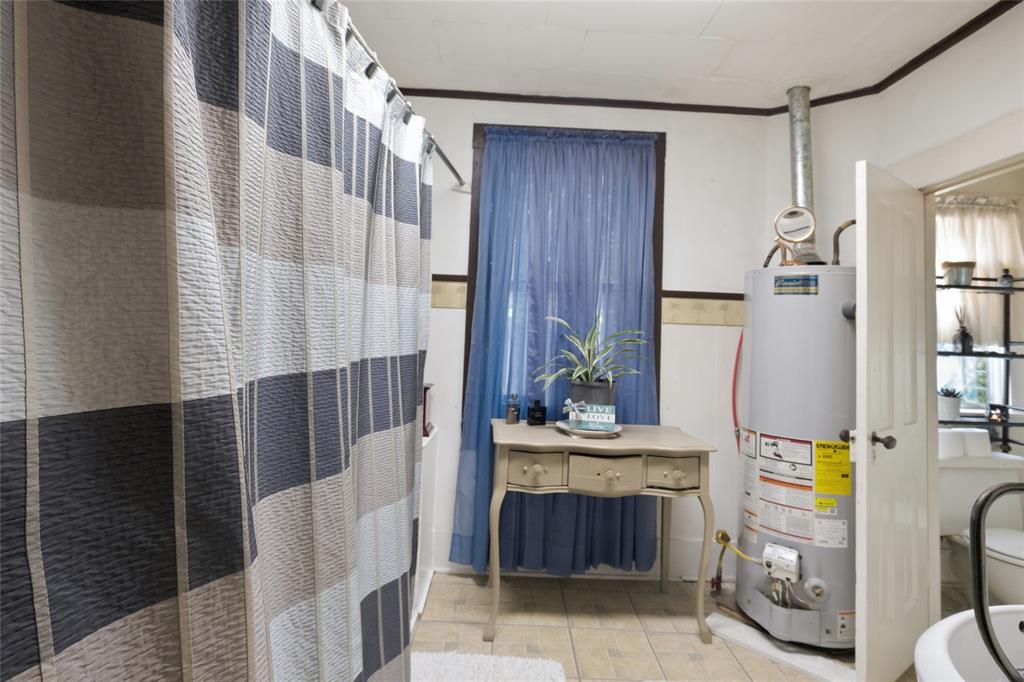 Bathroom featuring tile flooring and a vertical water heater