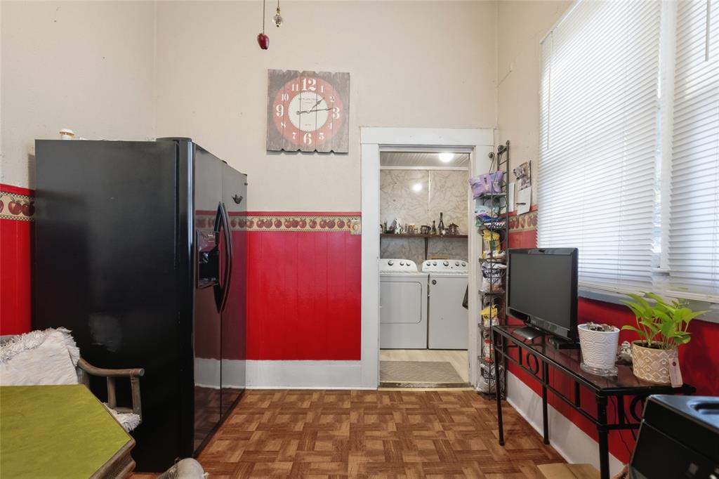 Kitchen area featuring wood-finish parquet flooring, two-toned wall detailing, and horizontal window blinds