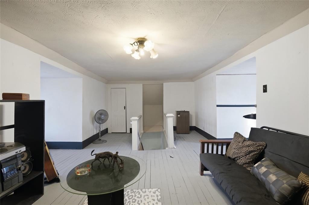 Painted wood-finish flooring, multi-bulb flush-mount ceiling light fixture, and white interior door