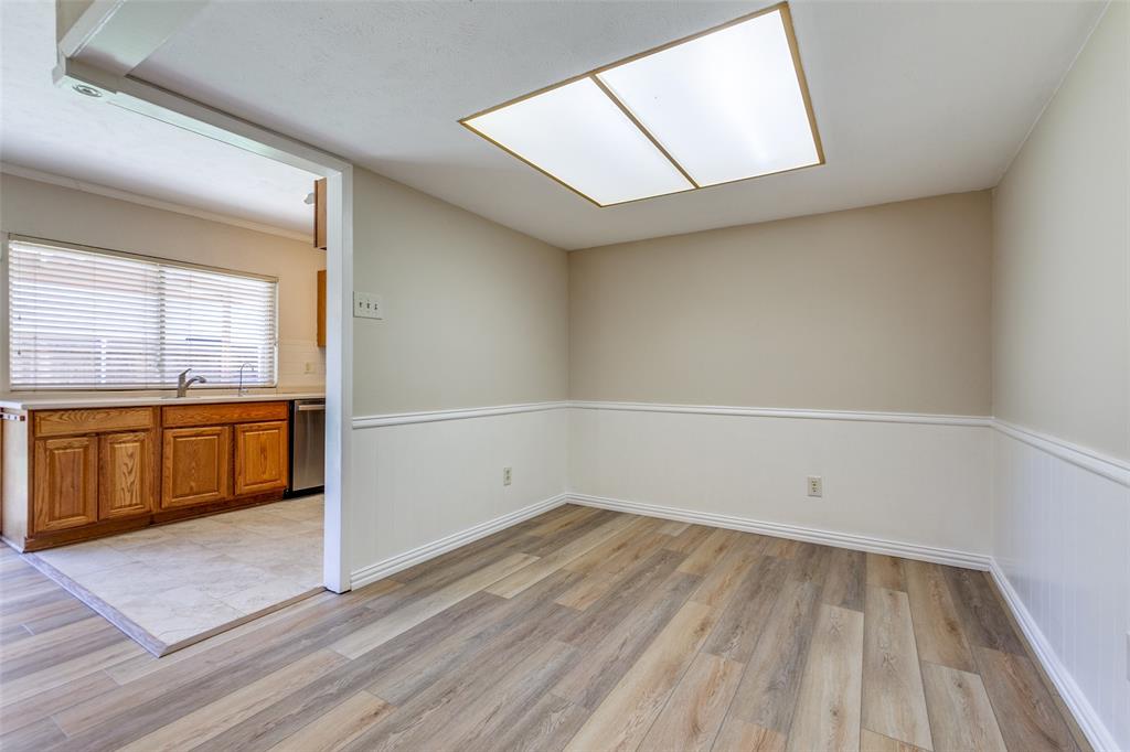 Room featuring wood-finish flooring, white chair rail molding, and a recessed ceiling light panel