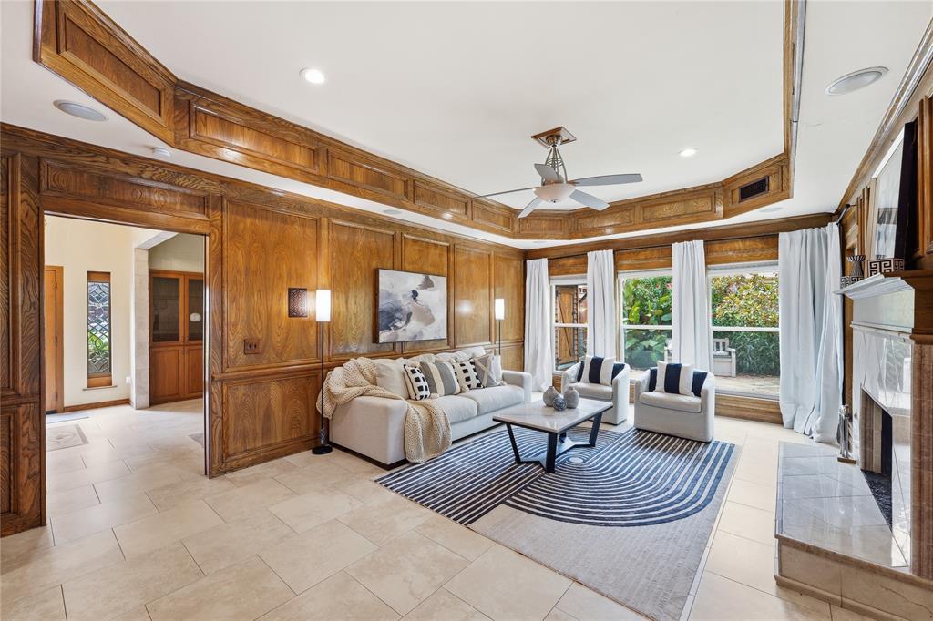 No carpet downstairs!  This family room is situated at the back of the home next to the amazing resort style backyard, offers oak paneling (real wood), tray ceiling and wall of windows.