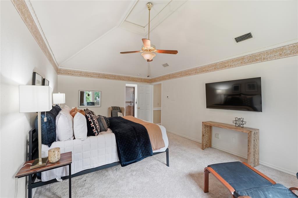Oversized Primary bedroom offers vaulted ceilings, a sitting area and a great view outside the picturesque street lined with trees.