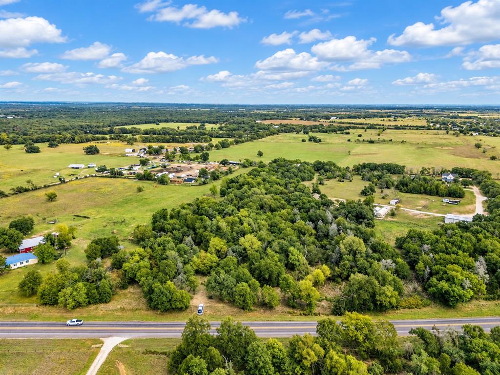 Expansive acreage featuring mature tree stands, cleared pasture land, and paved road frontage