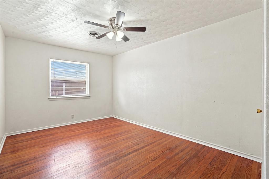 Room featuring wood-finish flooring, a ceiling fan with integrated lighting, a window with horizontal blinds, white baseboards, and a neutral wall color