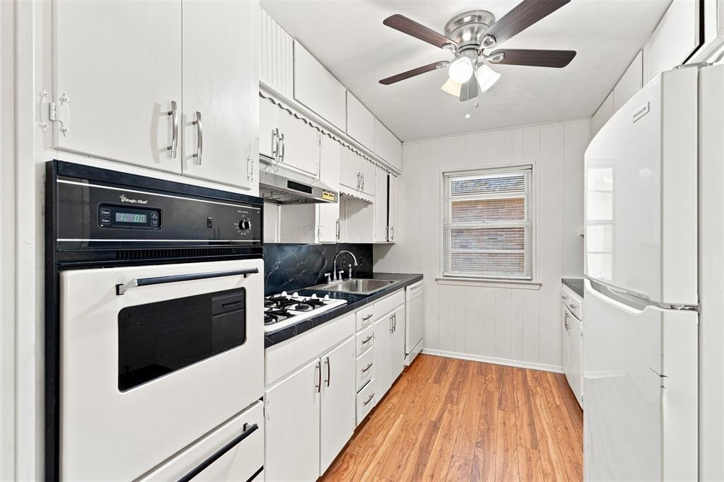 Kitchen featuring white cabinetry and wood-finish flooring