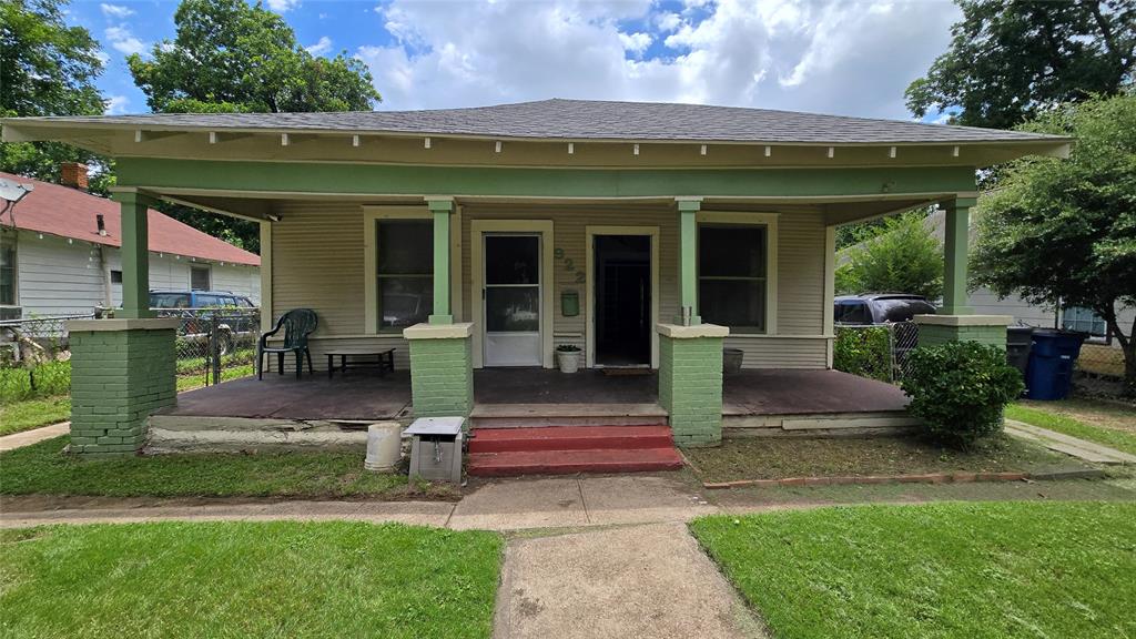 Craftsman-style exterior featuring a covered front porch, brick-based support columns, horizontal siding, and a hipped roofline