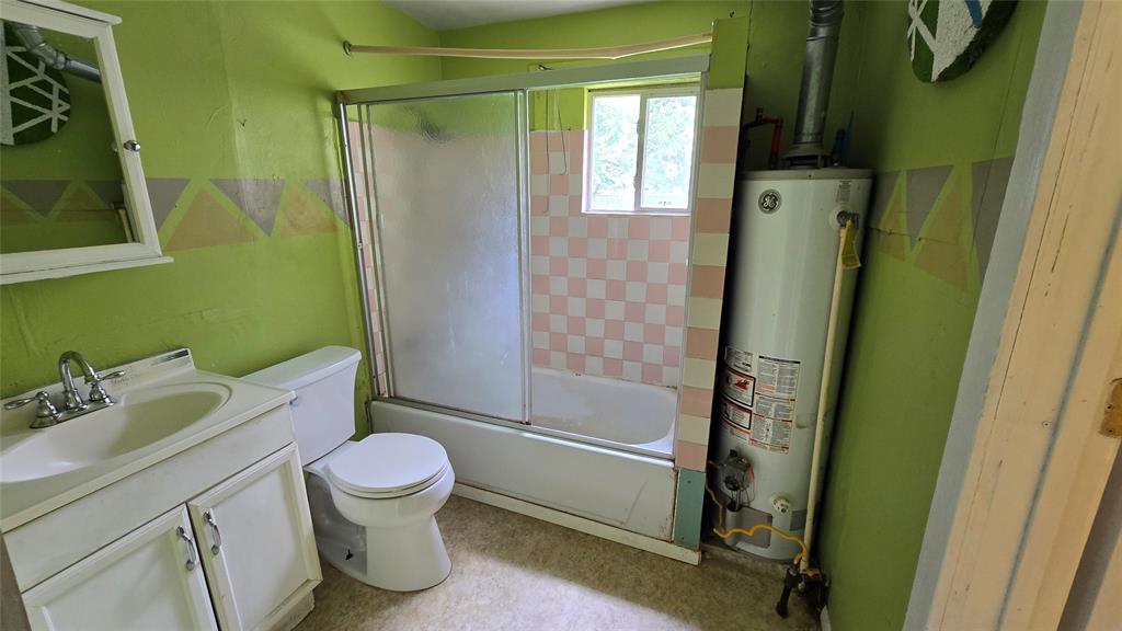 Bathroom featuring a white vanity cabinet, ceramic sink with a chrome faucet, bathtub-shower combination with sliding glass doors, and a tiled shower surround Bathroom featuring a white vanity cabinet, ceramic sink with a chrome faucet, bathtub-shower combination with sliding glass doors, and a tiled shower surround
