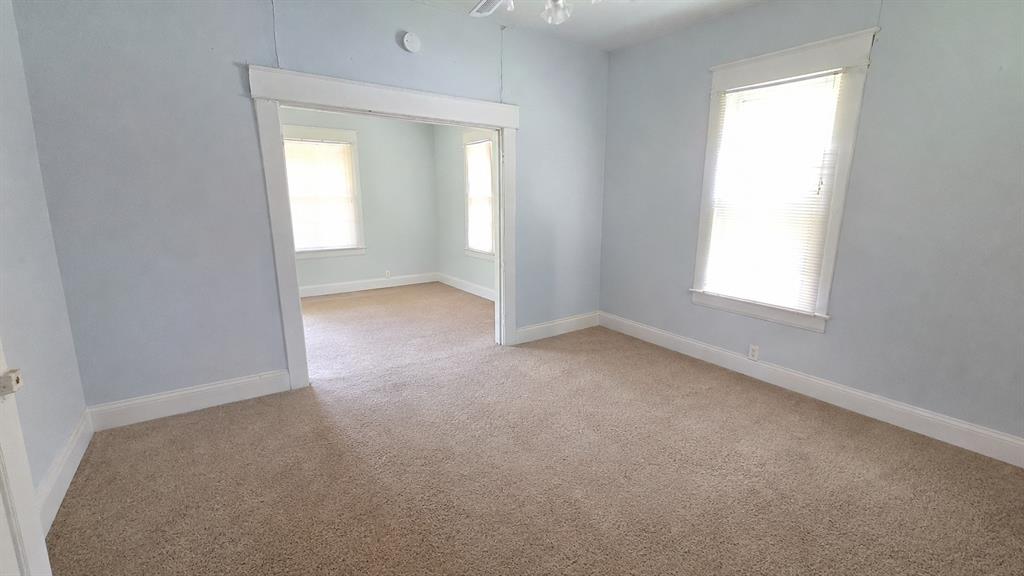 Interior space featuring neutral carpeting, wide window casing, and thick door trim