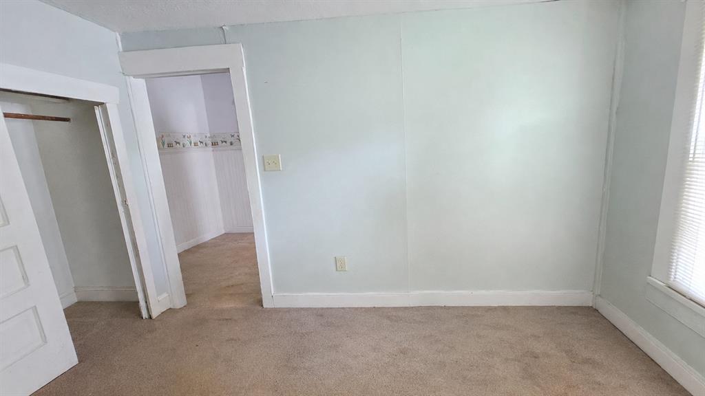 Neutral wall paint, carpeting, built-in closet, and interior doorway featuring white trim