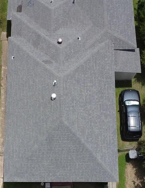 Aerial perspective of a multi-gabled architectural roofline featuring composite shingle roofing and integrated ventilation elements