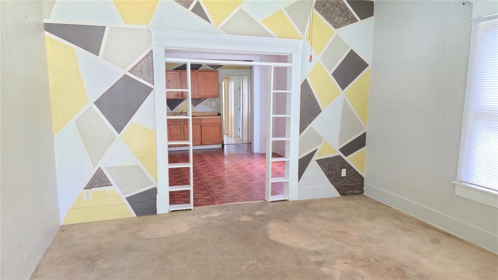 Interior room featuring geometric wall detailing and built-in side shelving surrounding a wide doorway