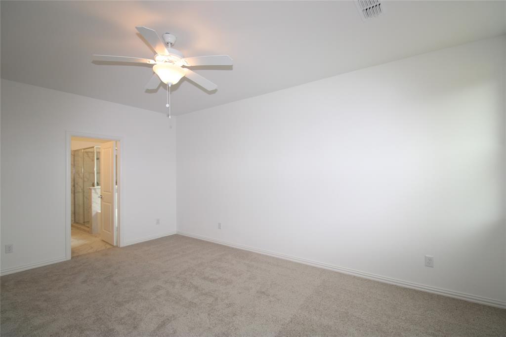 Neutral-toned wall-to-wall carpeting, high ceilings, and a central ceiling fan with an integrated light fixture
