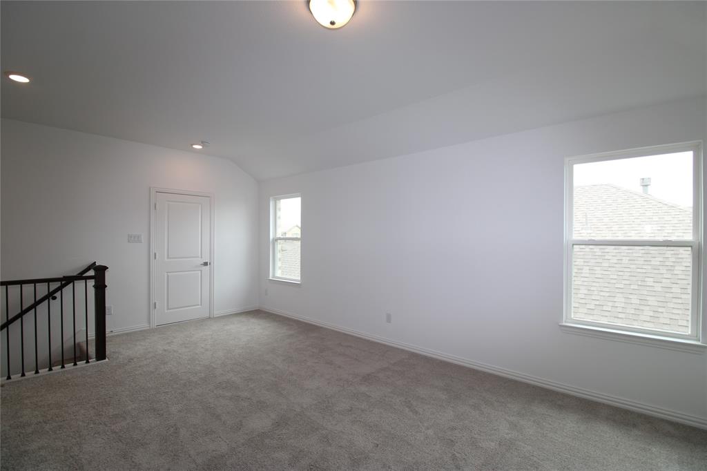 Neutral interior space featuring wall-to-wall carpeting, recessed lighting, dual windows, and a staircase with metal balusters