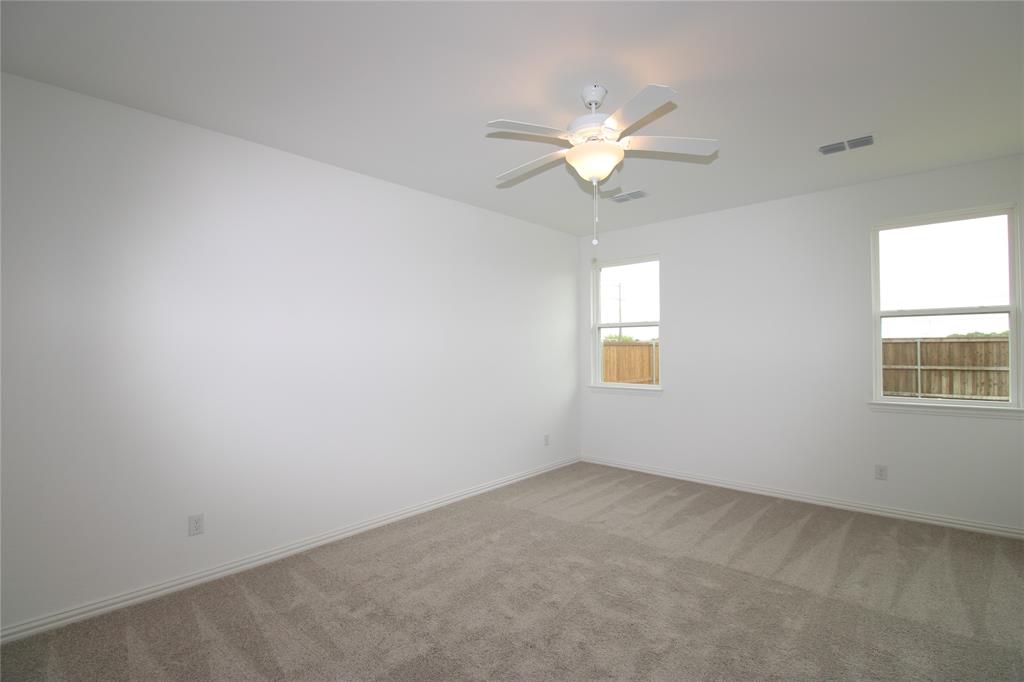 Interior room featuring neutral wall paint, wall-to-wall carpeting, two multi-pane windows, and a central ceiling fan with integrated lighting