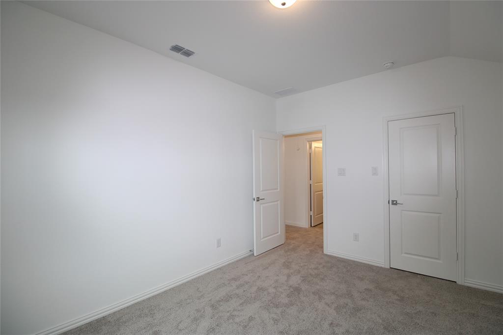 Neutral-toned carpeting, vaulted ceiling, and two-panel interior doors