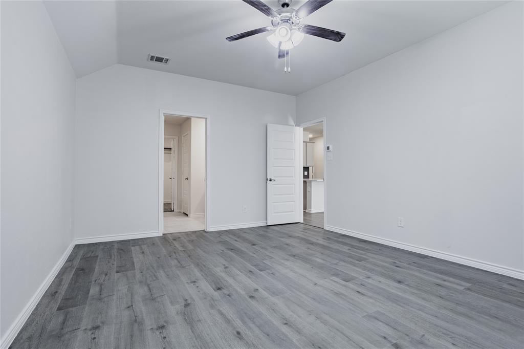 Room with vaulted ceilings, wood-finish flooring, and a central ceiling fan with integrated lighting
