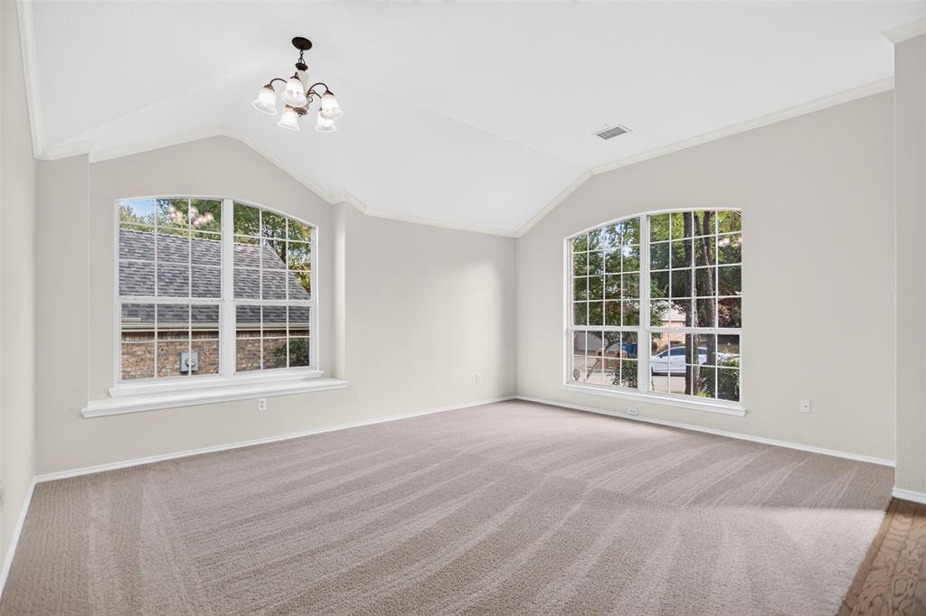 Vaulted ceilings featuring a multi-arm chandelier, large arched windows, and wall-to-wall carpeting Vaulted ceilings featuring a multi-arm chandelier, large arched windows, and wall-to-wall carpeting