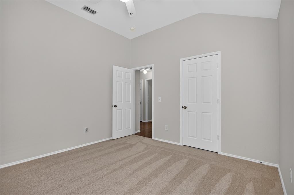 Vaulted ceilings, neutral wall palette, carpeting, and interior six-panel doors