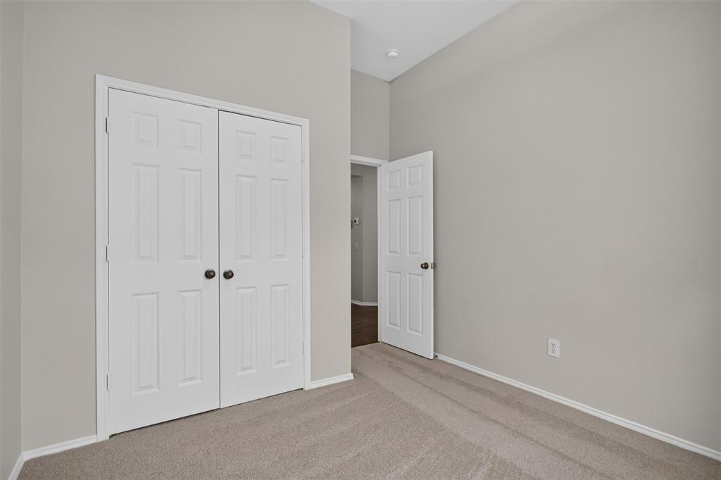 Interior space featuring neutral wall tones, high ceilings, carpeting, and six-panel doors